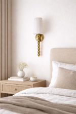 Modern classic brass wall sconce with pleated fabric shade for elegant presence